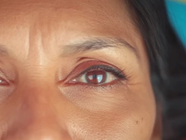 Close-up dos olhos de uma mulher em um fundo azul.