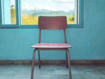 Uma cadeira de madeira em frente a uma janela aberta com uma vista panorâmica da montanha.