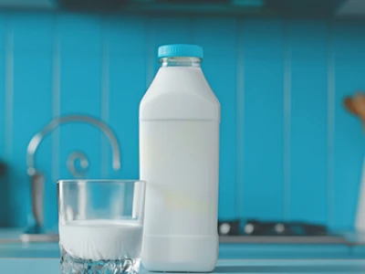 Garrafa e copo de leite em um balcão de cozinha com azulejos azuis.