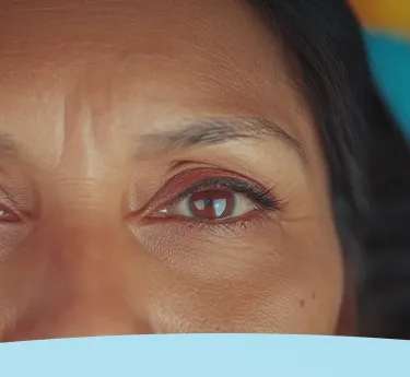 Close-up dos olhos de uma mulher em um fundo azul.