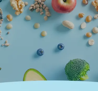Frutas, nozes, sementes e legumes espalhados em um fundo azul.