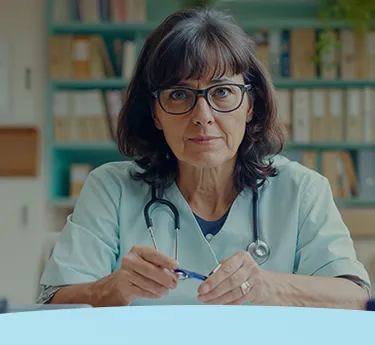 Médico vestindo uniforme e estetoscópio, sentado em um consultório médico com estantes de livros.