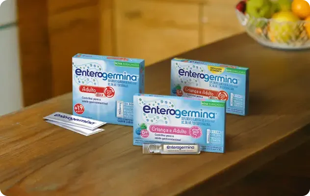 Linha Enterogermina: Adulto MAX (+19) e Criança e Adulto (0+) em uma mesa de madeira.