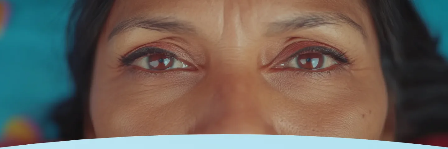 Close-up dos olhos de uma mulher em um fundo azul.