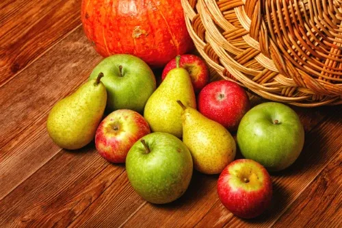Imagem de cesto de frutas com várias frutas em volta.
