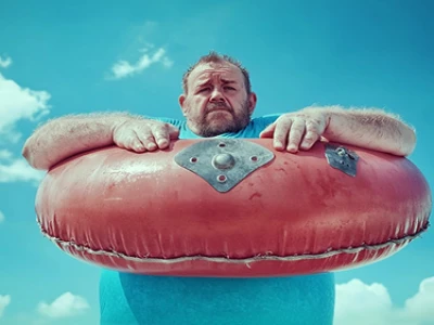 Homem em uma piscina segurando um grande anel de flutuação vermelho.