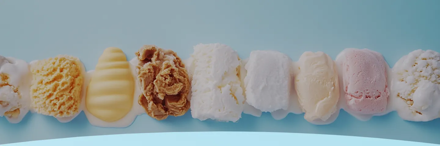 Uma fileira de colheres de sorvete de diferentes sabores em um fundo azul claro.