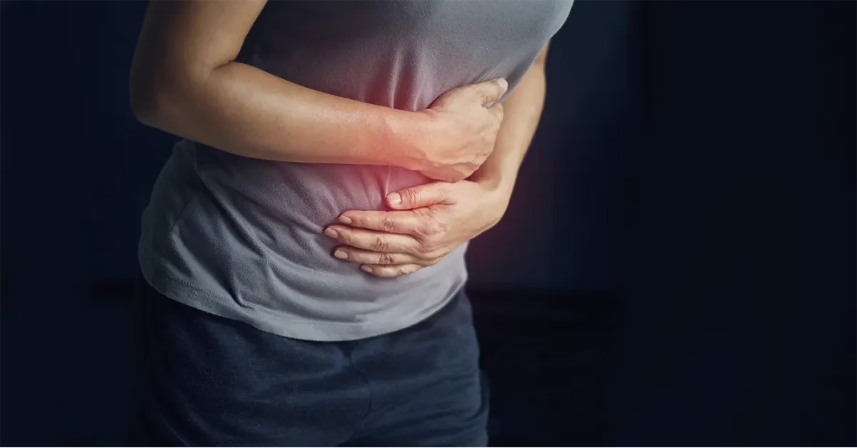 Mujer con dolor en el estómago agudo. El dolor suele ser un síntoma de la diarrea.
