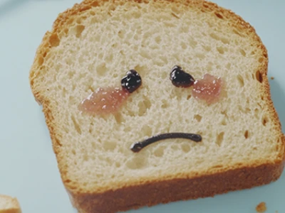 mulher com uma mão na barriga e outra segurando um feixe de trigo