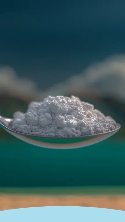 Colher de prata segurando um monte de pó branco com um fundo desfocado.