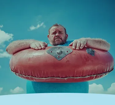 Homem descansando em um grande tubo interno vermelho em um cenário de céu azul.