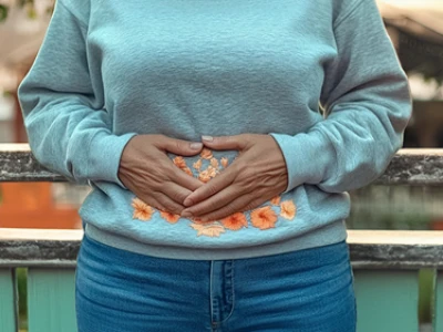 Pessoa de suéter e jeans segurando a barriga com bordado floral.