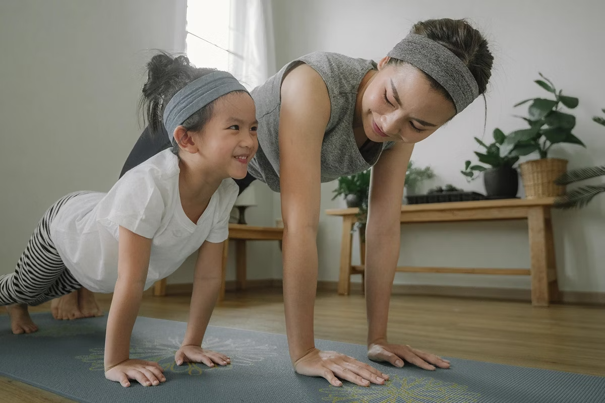 Mamá e hija practicando Yoga para estimular el cuerpo y mejorar la salud. 