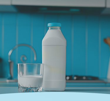 Uma garrafa de leite e um copo cheio em um balcão de cozinha com um backsplash azul.