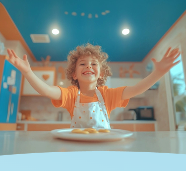 Criança com cabelo cacheado sorrindo e usando um avental em uma cozinha colorida.