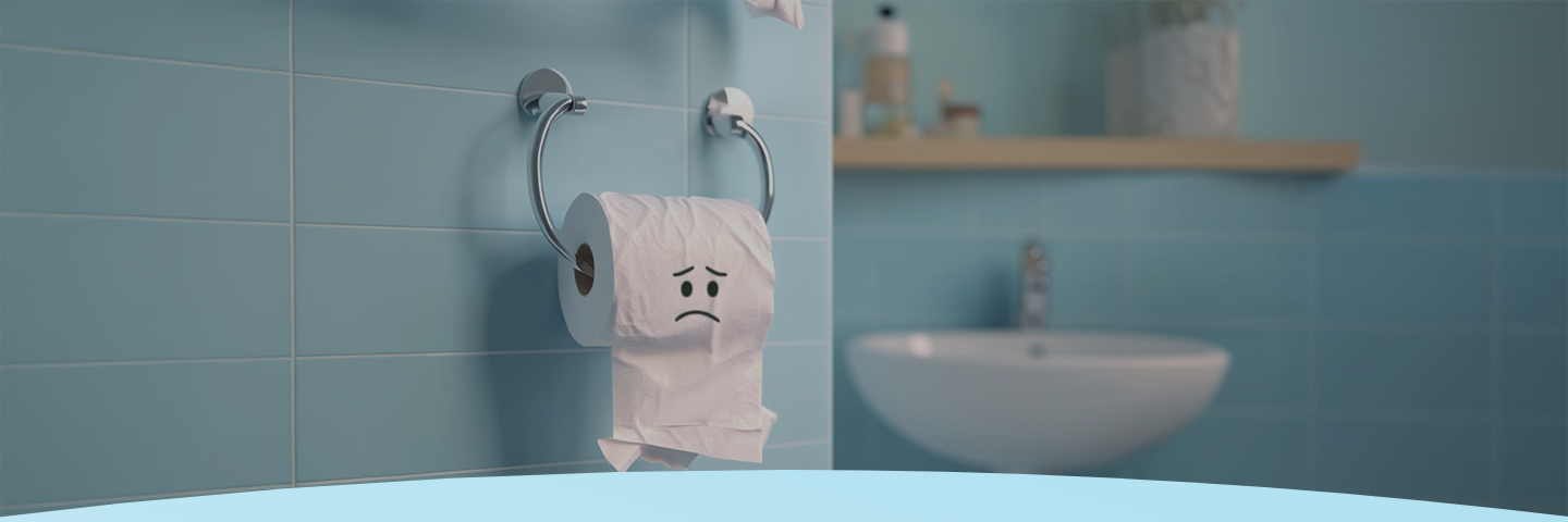 Papel higiênico com um rosto triste em um banheiro de azulejos azuis.