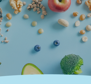 Frutas, nozes, sementes e legumes espalhados em um fundo azul.