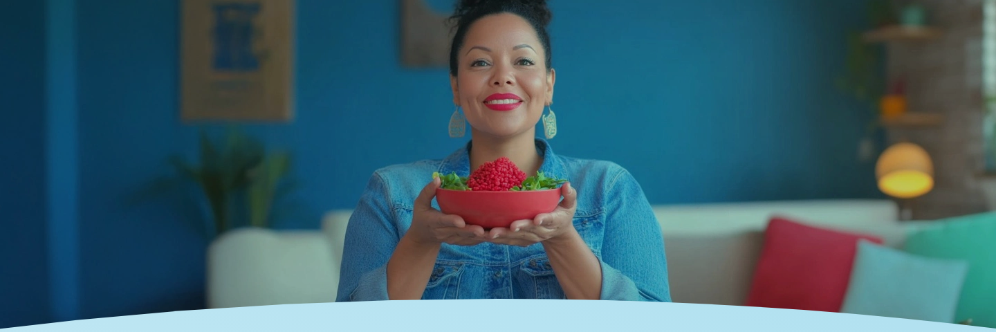 Mulher sorridente segurando uma tigela de quinoa vermelha e verduras.